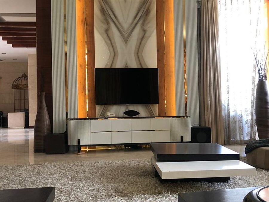 Fluted panelling and backlit marble TV feature wall in a villa living room