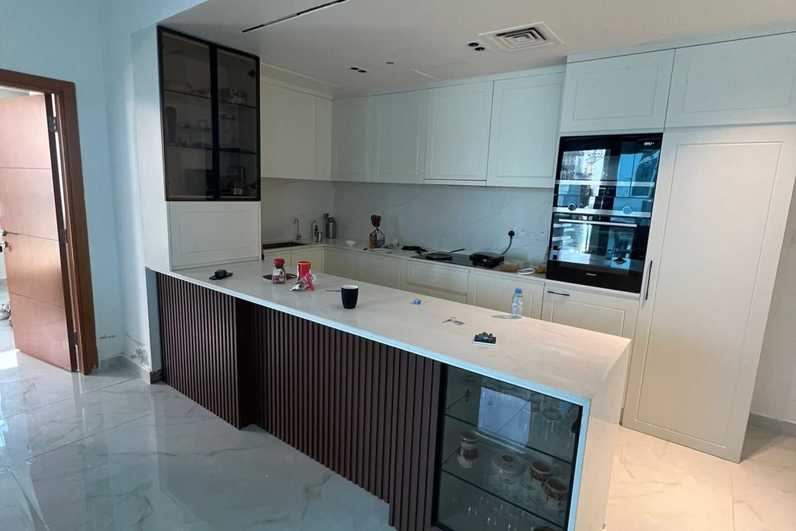 Shaker kitchen with fluted timber peninsula, wine cooler and marble-effect worktop