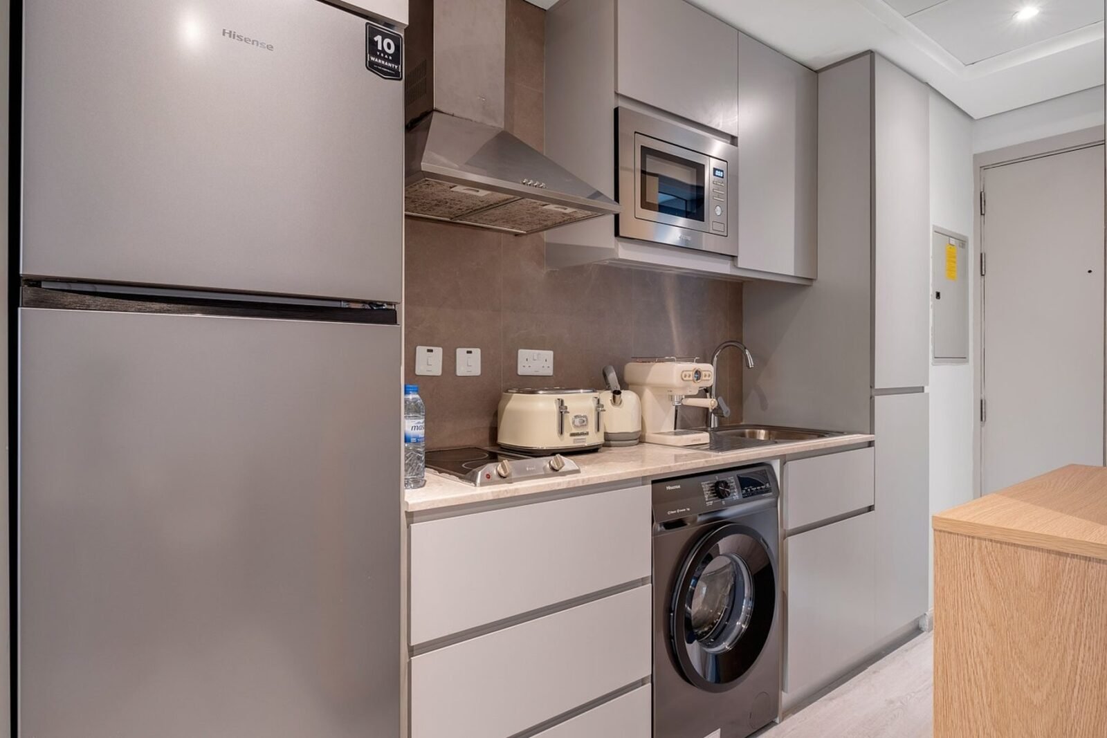 Compact handleless galley kitchen with integrated laundry in a Dubai Marina apartment