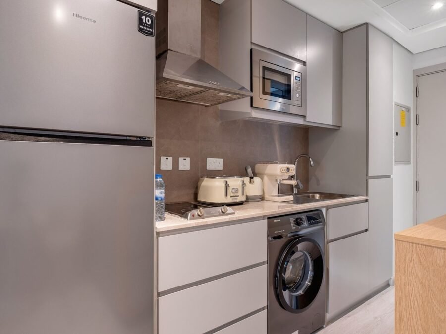 Compact handleless galley kitchen with integrated laundry in a Dubai Marina apartment